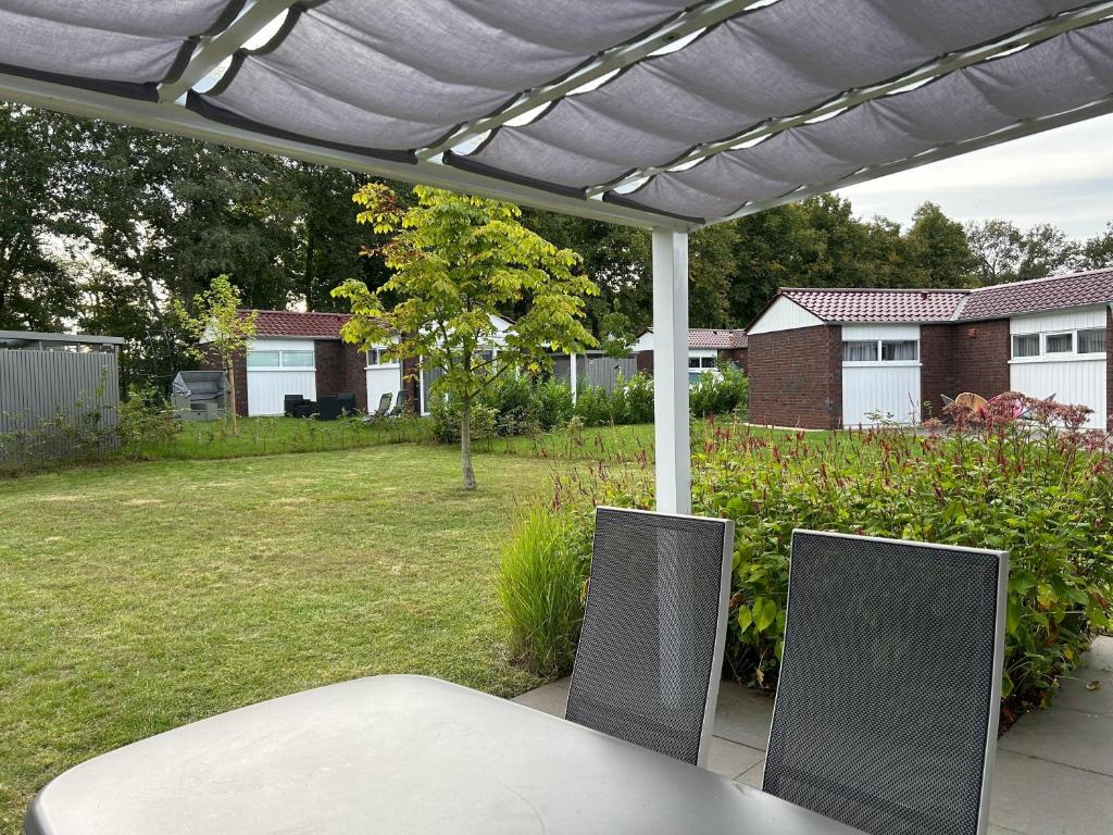 a patio with a table and chairs under a pergola at Haus 21 am See in Schüttorf