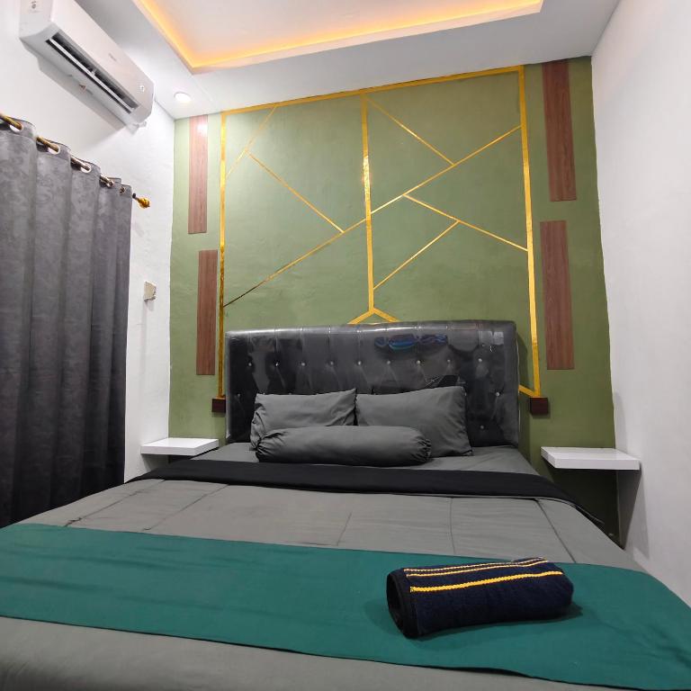 a bedroom with a bed with a green wall at Wisma 11 Oktober in Palangkaraya