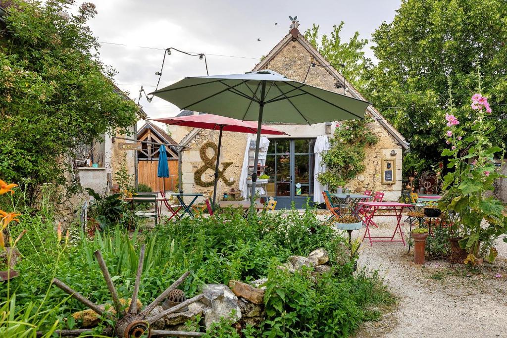a patio with a table and an umbrella at Dordinaire Maison D'hôtes in Nouans-les-Fontaines