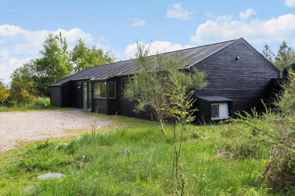 a black house in the middle of a field at 0259-Romo-Lyngvejen-89-B in Høm