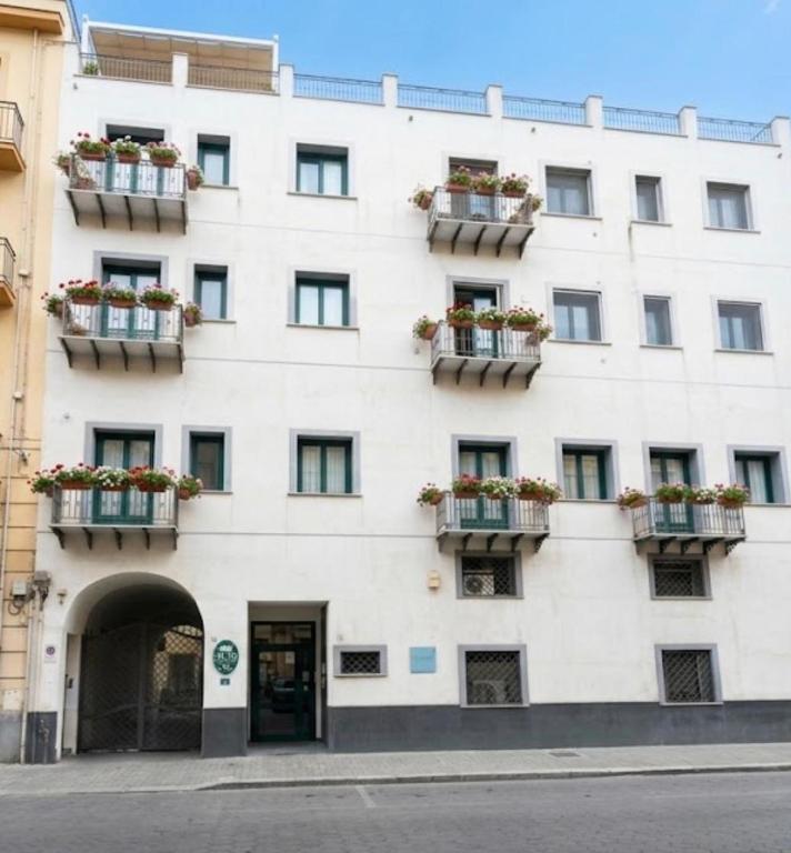 a white building with flowerpots on its windows at B&B Alla Stazione in Palermo