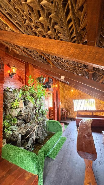 a room with a stone wall with a bench and plants at Wonderful Hostel Trincomalee in Trincomalee