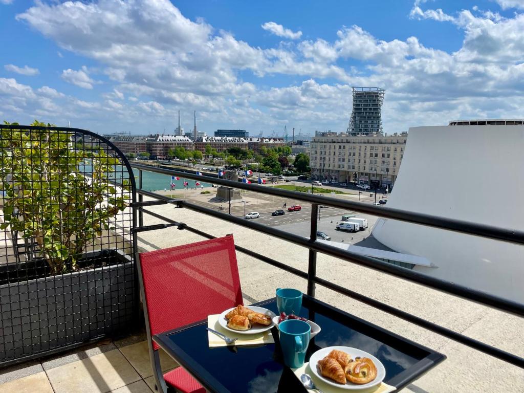 a table with two plates of food on a balcony at Best Western ARThotel in Le Havre