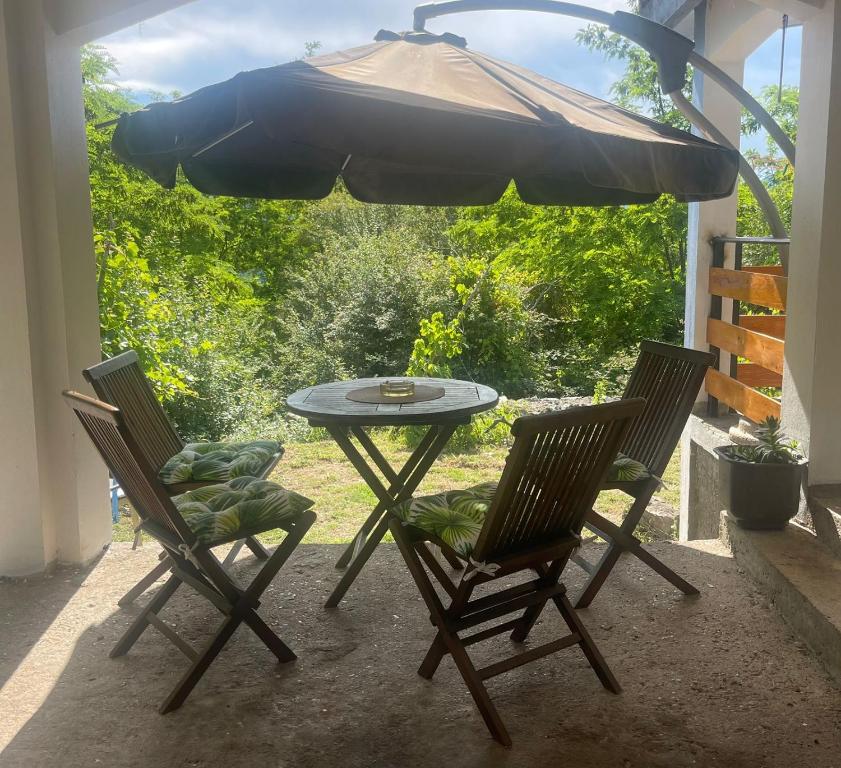 a patio table with two chairs and an umbrella at Tresnjin hlad in Limljani