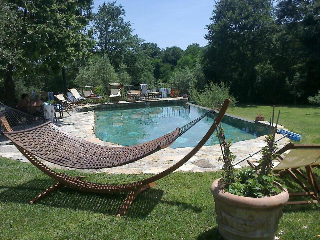 a hammock in a yard next to a swimming pool at Podere Stollo in Sassetta