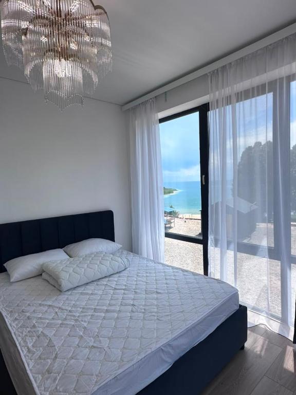 a bedroom with a large bed and a large window at Парус in Cholpon-Ata