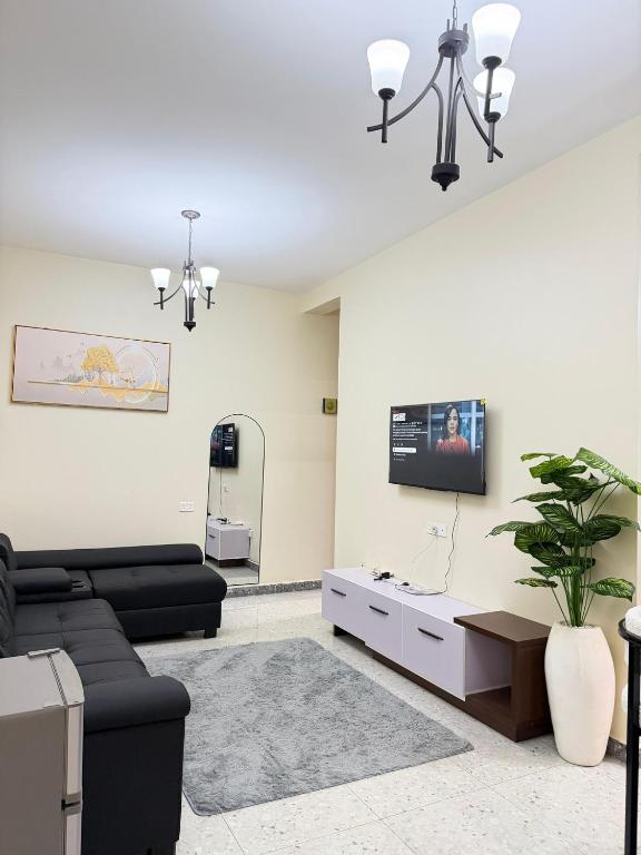 a living room with a couch and a tv at Modern 1BR Apartment with Pool & Sauna Kampala in Kira