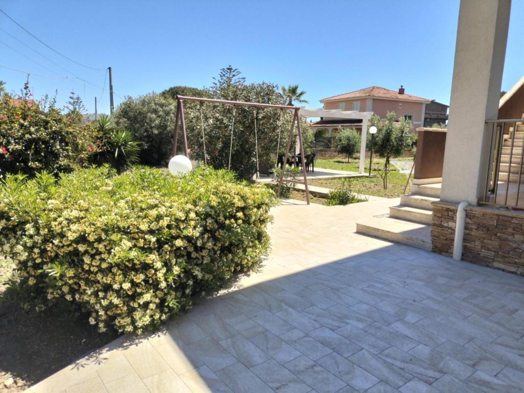 a garden with a swing and a bush at A Casa Mia in Butera