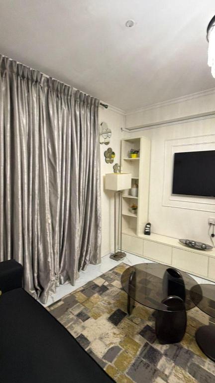 a living room with a television and a glass table at Ivaeli Apartment in Lagos