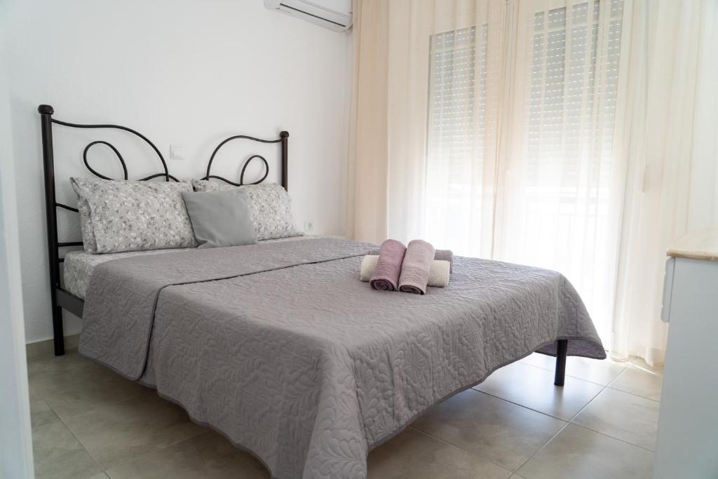 a bedroom with a bed with two towels on it at Rodostagma 2 in Rodholívos