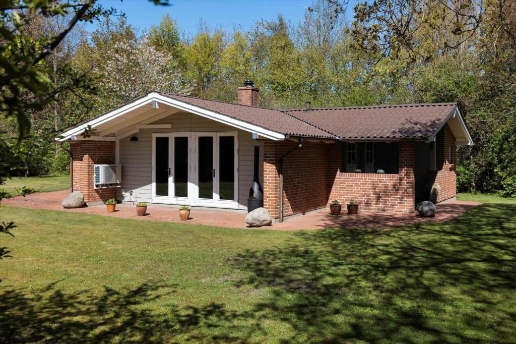 a brick house with a front porch and a yard at LF14348-Roslev-Harrebjergvej-48 in Harre