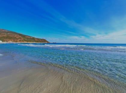 a beach with the ocean and the shoreline at Vacances El Haouaria in El Haouaria