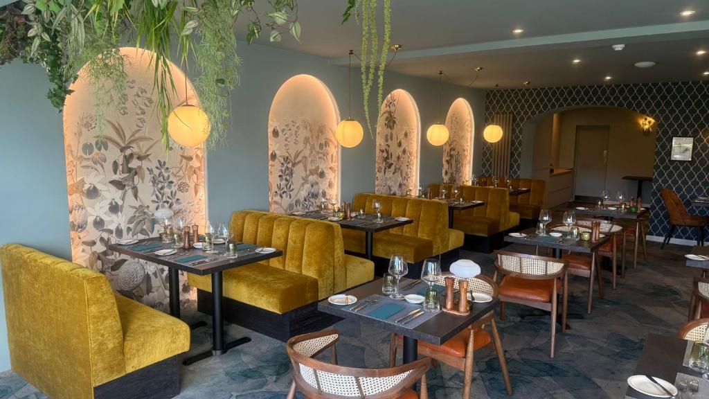 a dining room with tables and yellow chairs and tablesktop at Pandora Hotel in St. Peter Port