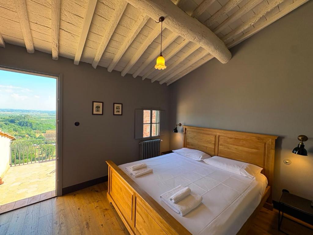 a bedroom with a large bed and a large window at Le 3 Rane B&B in Treggiaia