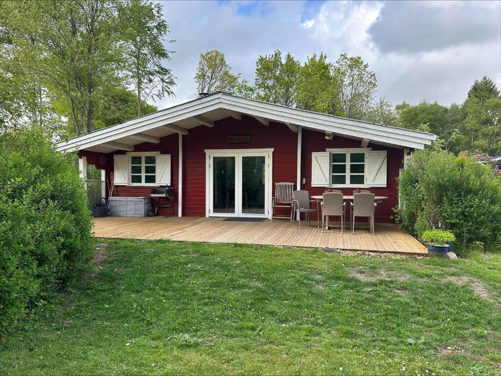 a red house with a deck and chairs on it at 0663-Toftlund-Midtparken-84 in Toftlund