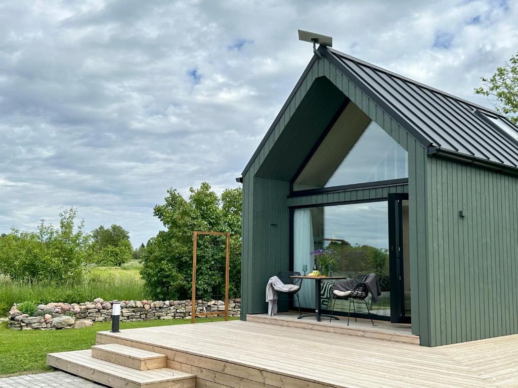 a green shed with a table on a deck at Greencabin - Cabin Escape in the Heart of Saaremaa in Pamma