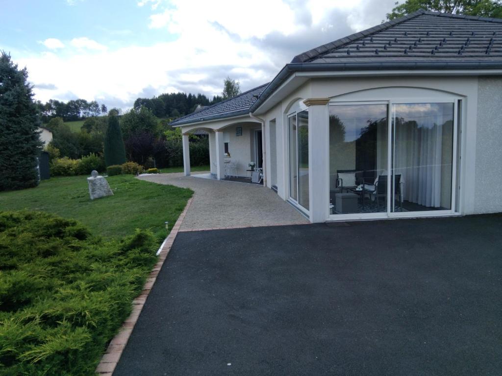 a extension to a house with a patio at Haute-loire Tence Belle maison neuve plain-pied 4 étoiles avec parc arboré clos in Tence