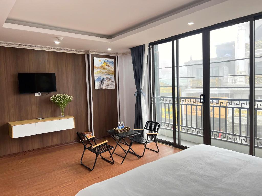 a bedroom with a bed and a tv and a table at Sa Pa Camellia Hotel in Sapa