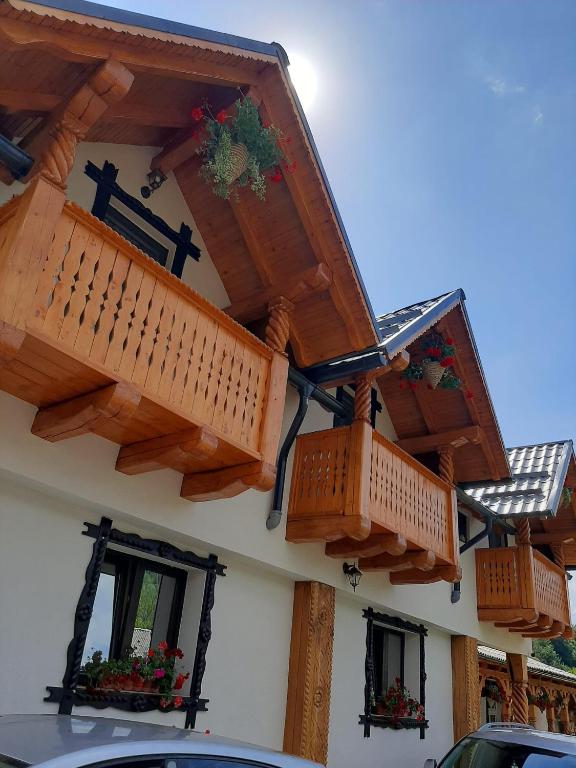 a building with wooden balconies on the side of it at Domeniul Ursului in Valea Stejarului