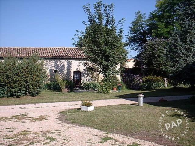 a stone house with a yard with a driveway at Gite de la Maison Noble in Champagné-le-Sec