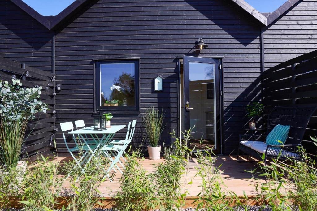 a black house with a patio with a table and chairs at 13503-Vig-Lyngvej-107-4 in Vig