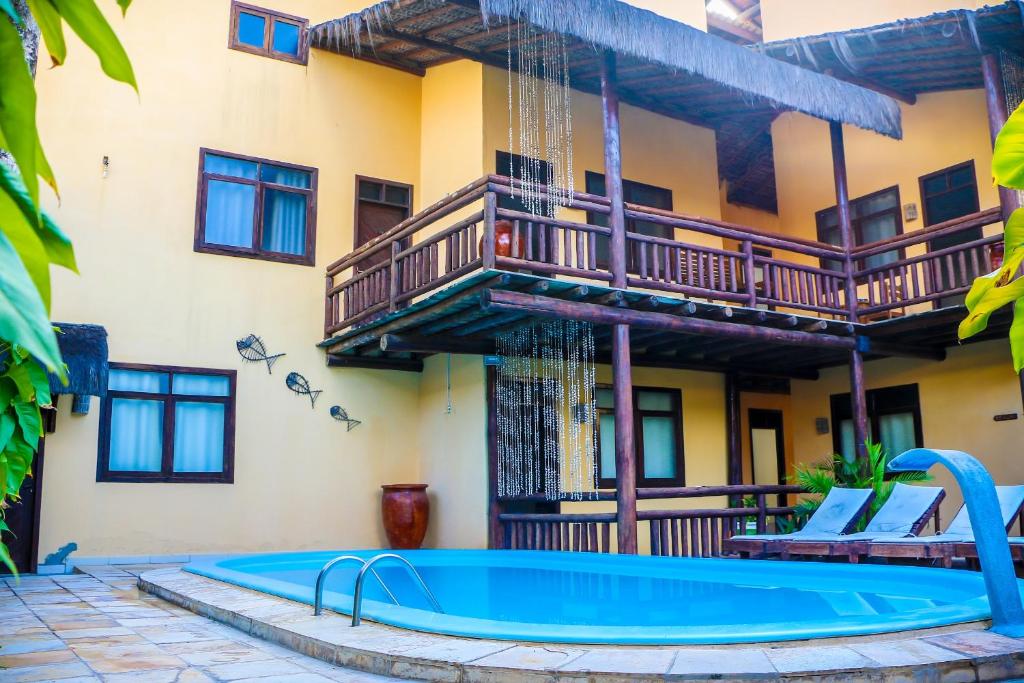 a resort with a pool and a balcony at Pousada Capitães de Areia in Porto De Galinhas