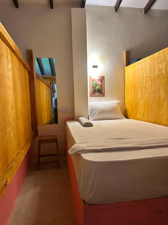 two beds in a small room with two windows at AAA Happy Hostel in Arugam Bay