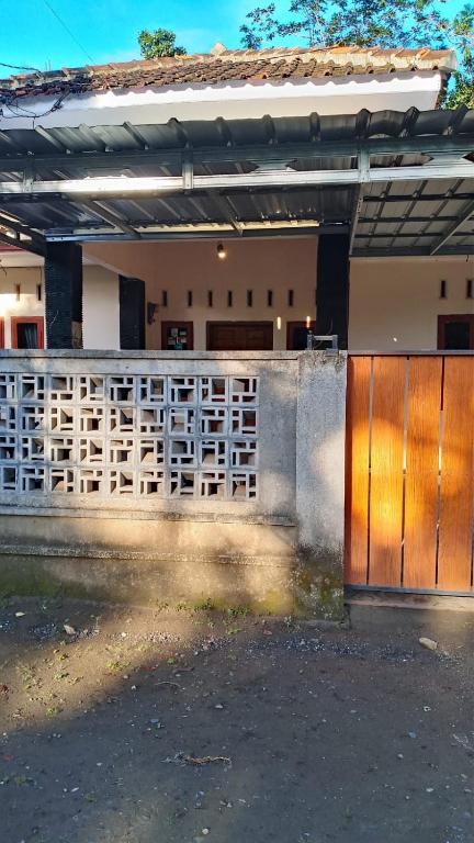 a fence in front of a house with a gate at Thian Homestay in Batukaras
