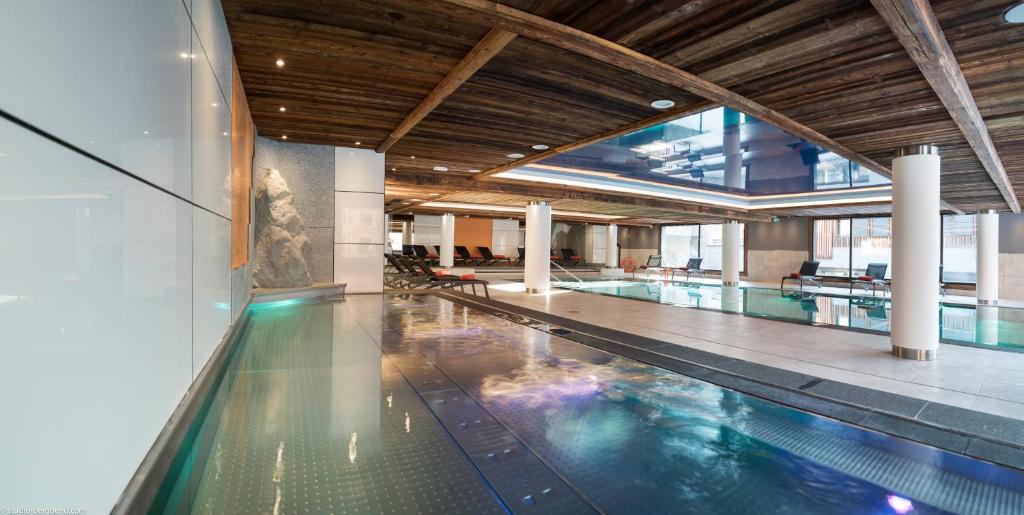 a large swimming pool in a building with a pool at Résidence Le Cristal de Jade in Chamonix-Mont-Blanc