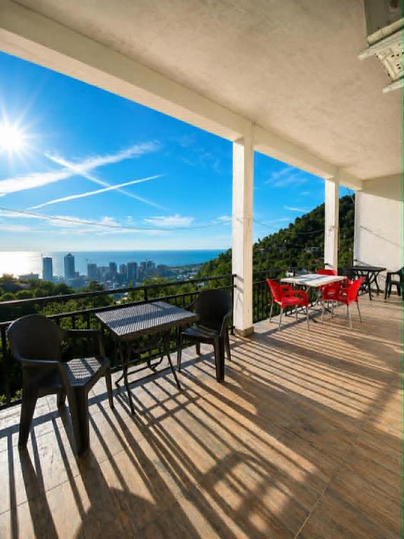 a balcony with tables and chairs and a view of the city at Guesthouse Tornike in Gonio