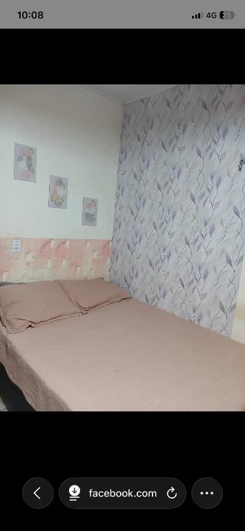 a picture of a bedroom with a bed and a wall at Suítes em Parintins in Parintins