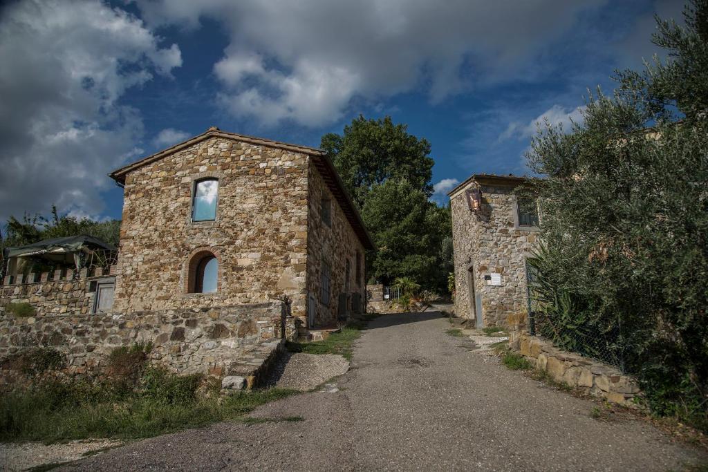 an old stone building on the side of a road at Borgo Medievale di Poggio Alla Pieve Relais, Food & Art in Calenzano