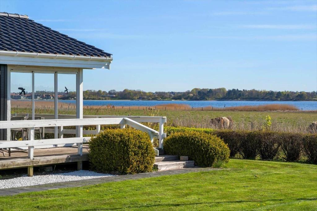 a wooden gazebo in a field with a lake at FJ1601-Jaegerspris-Strandleddet-25 in Jægerspris