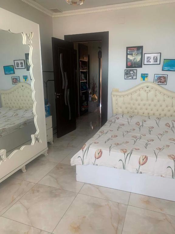 a bedroom with a white bed with flowers on it at Memed abashidzis 16 in Kobuleti