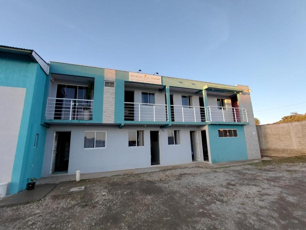 a blue and white building with a parking lot at Pousada Por do Sol in Lapa