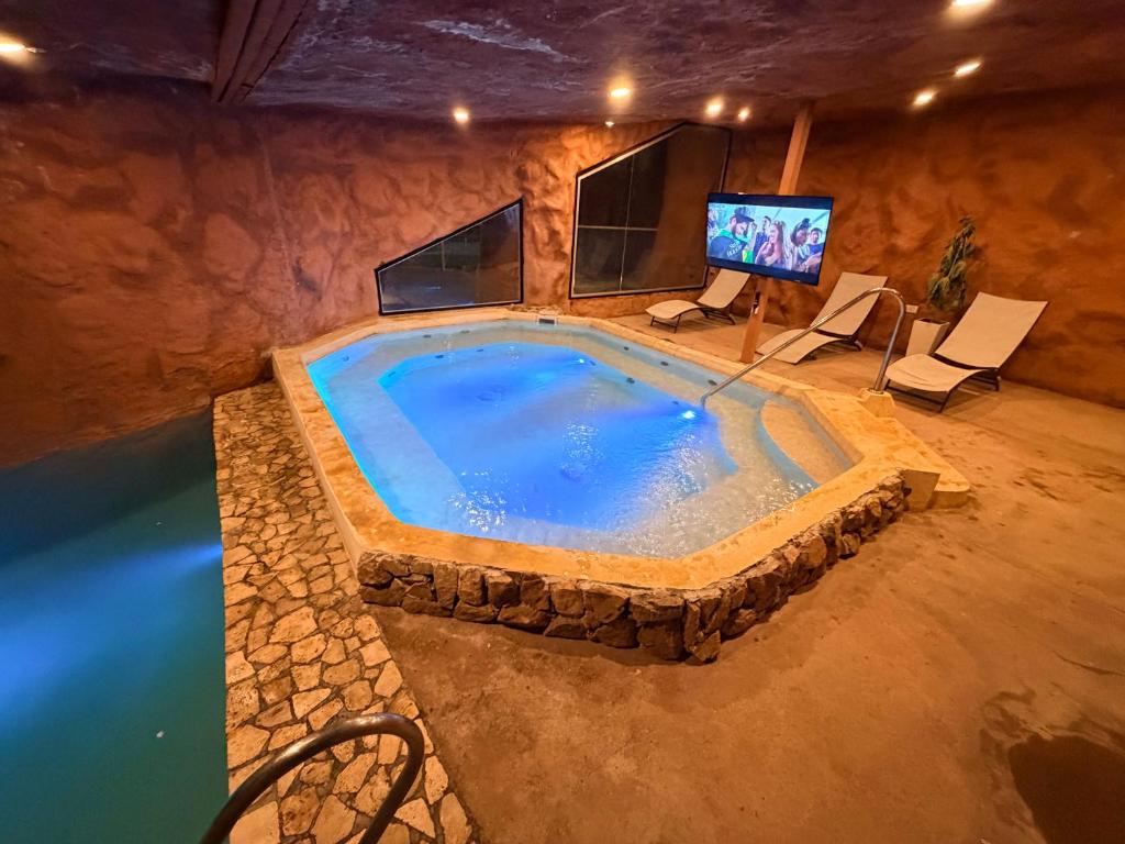 a large swimming pool with a tv in a room at La Guadalupe Cabañas in La Rioja