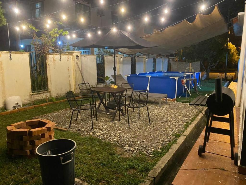 a patio with a table and chairs under an umbrella at Yasmeen pool cottage in Temerloh