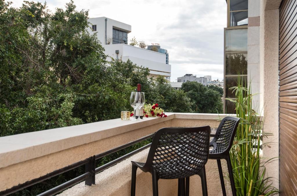 2 sedie sedute sul balcone di un edificio di Reines5 TLV a Tel Aviv