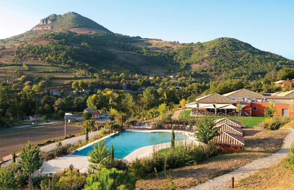 a swimming pool with a mountain in the background at Domaine Saint Esteve in Millau