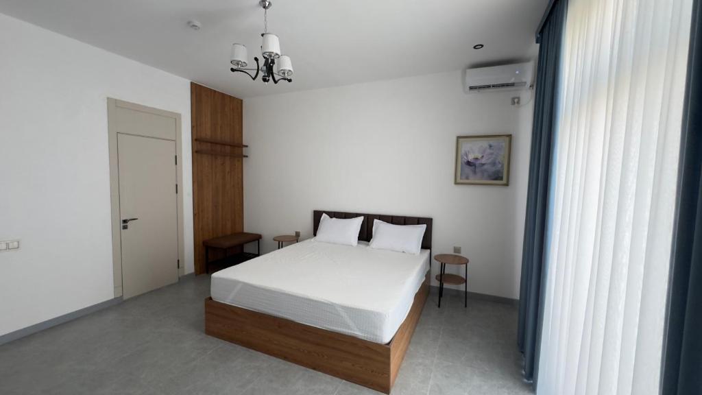 a bedroom with a bed with white sheets and pillows at Humor Hotel in Tashkent