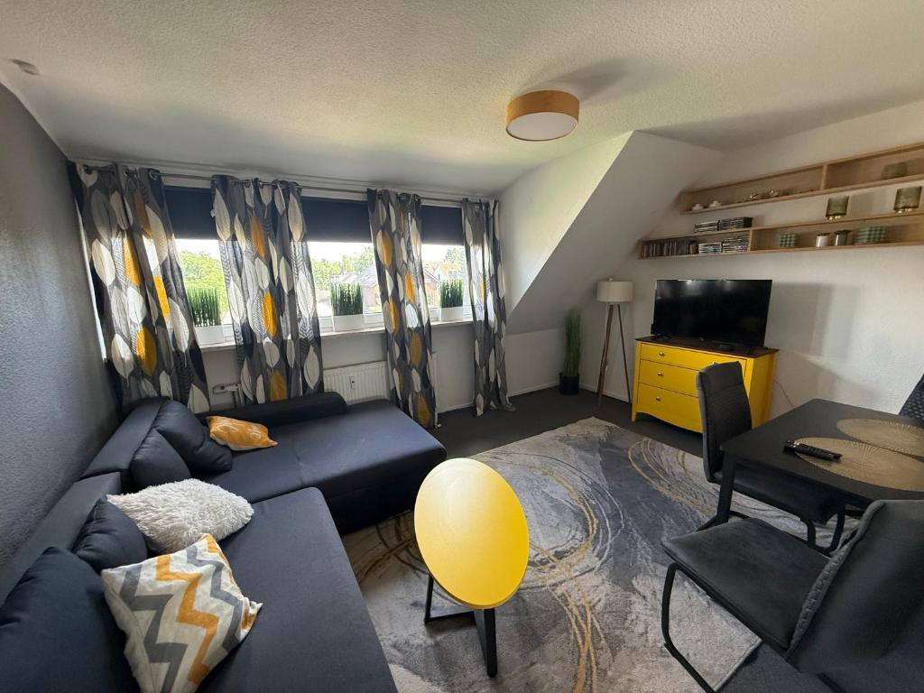 a living room with a blue couch and a television at Apartment Schmachtendorf in Oberhausen