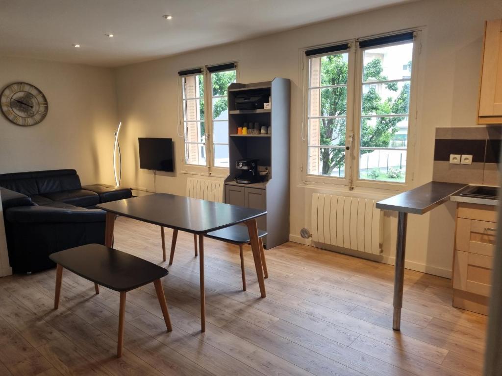 a living room with a table and a couch at Chambre proche du Polygone scientifique - EdF - Schneider - GEM in Saint-Martin-le-Vinoux