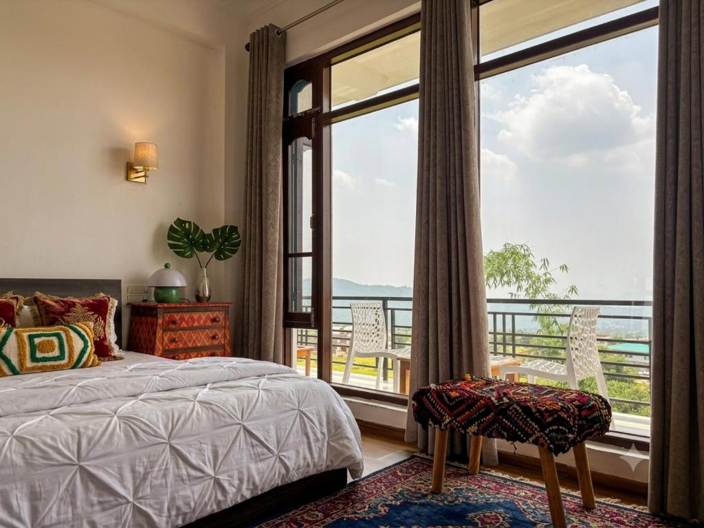 ein Schlafzimmer mit einem Bett und einem großen Fenster in der Unterkunft Draft Hotel Bir Billing At Landing Site in Bir