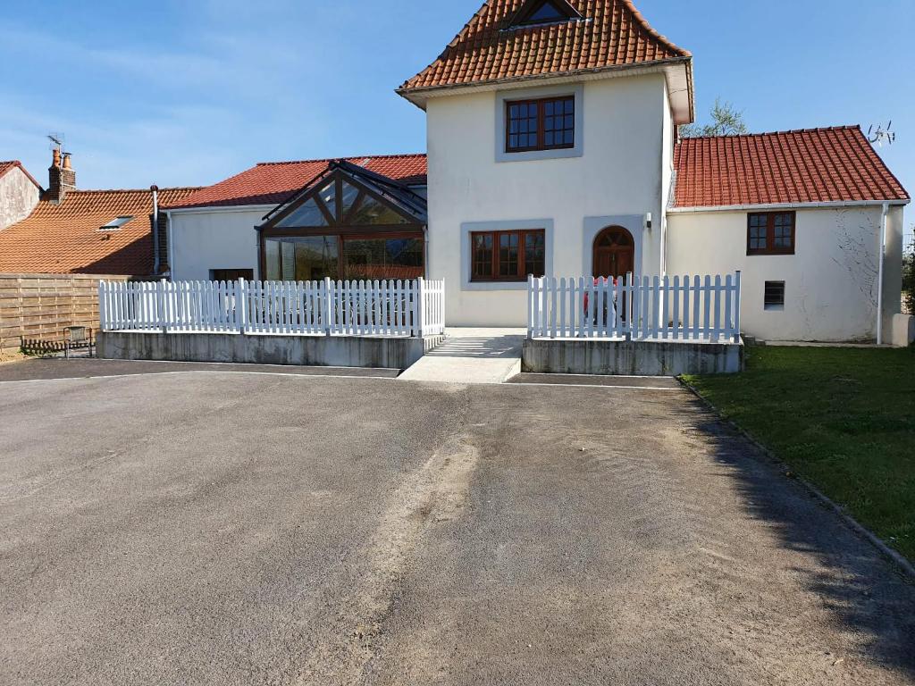 a white house with a white fence in front of it at La Cantraigne in Audembert