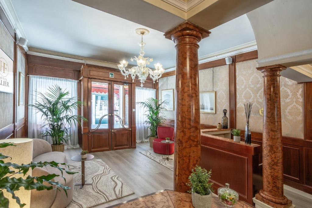 a living room with columns and a chandelier at Hotel Falier in Venice
