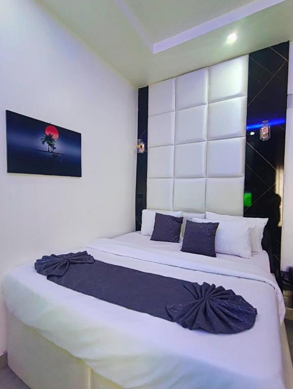 ein Schlafzimmer mit einem großen weißen Bett und schwarzen Kissen in der Unterkunft Dpounds Hotel & Suites in Okinano