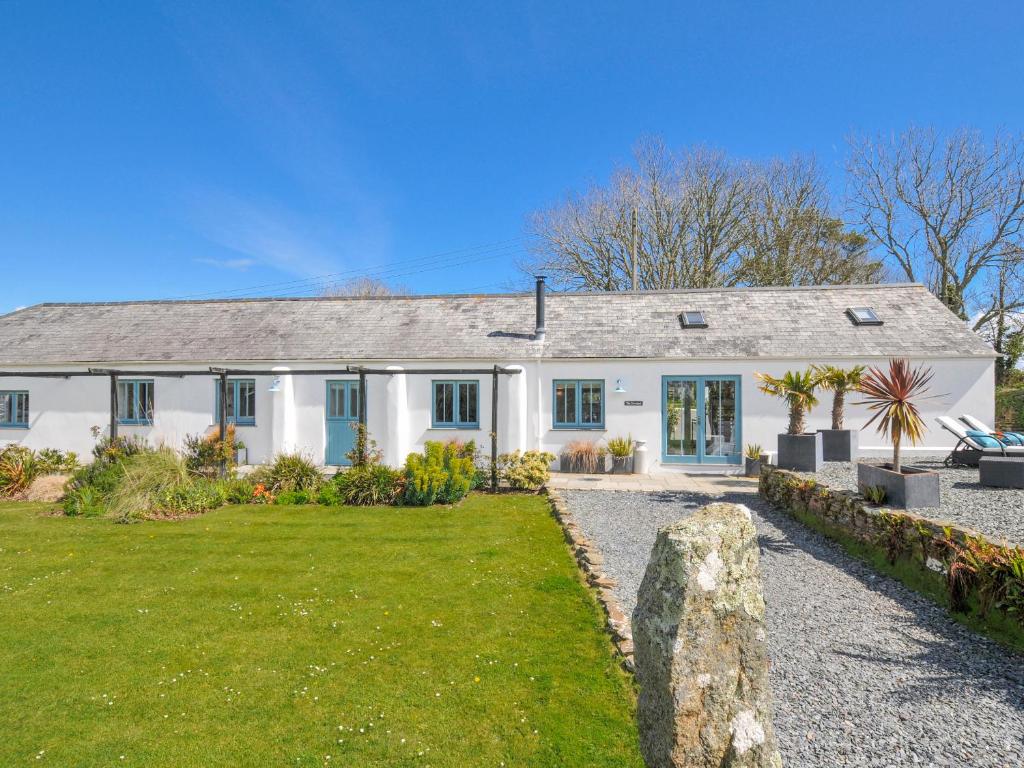 a white house with a garden in front of it at The Cowshed in Truro