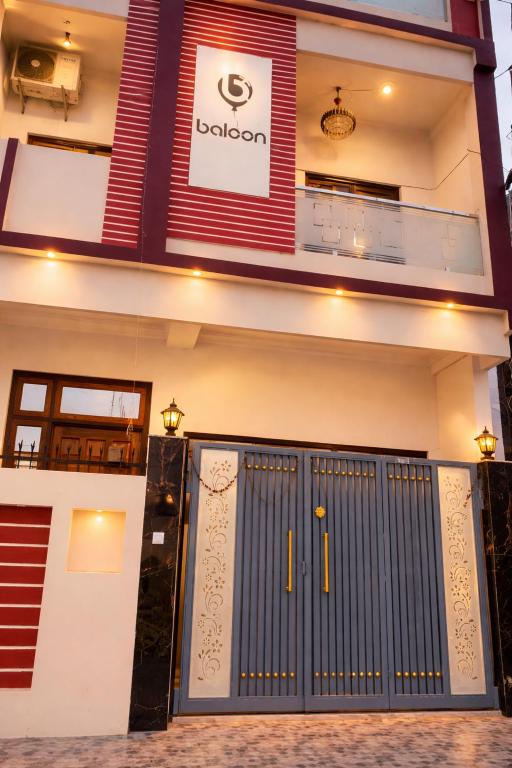 a building with a blue gate in front of it at Baloon Rooms Taramandal in Gorakhpur