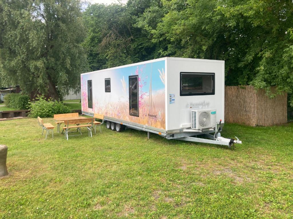 a trailer parked in a yard with a table at TinyHouse am Stadthafen in Hennigsdorf