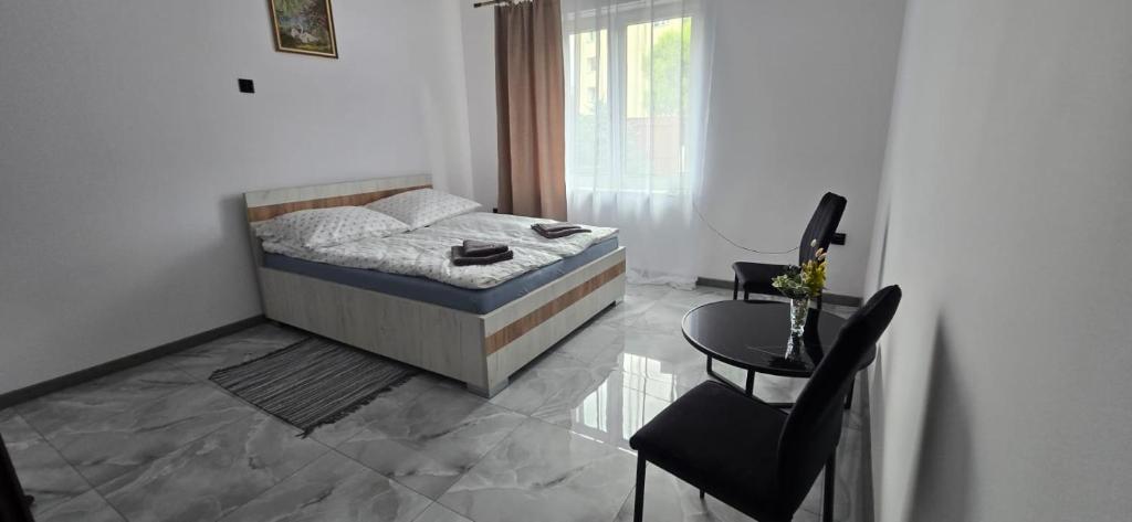 ein Schlafzimmer mit einem Bett, einem Tisch und einem Stuhl in der Unterkunft Jarocin in Jarocin